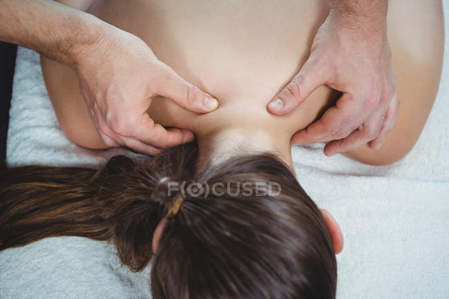 Primer plano del fisioterapeuta que da fisioterapia a la espalda de la paciente femenina en la clínica - foto de stock
