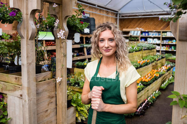 Portrait of smiling female florist standing in garden centre — Stock Photo