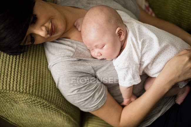Primo piano di mamma e bambino che dormono sul divano in soggiorno a casa — Foto stock