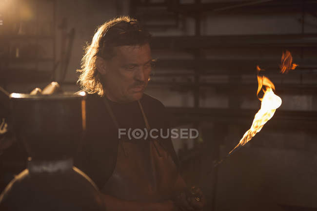 Blacksmith holding a welding pipe in workshop — Stock Photo