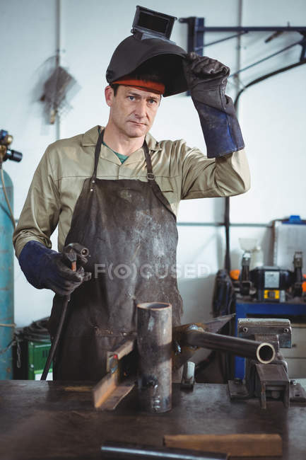 Portrait of welder holding welding machine in workshop — Stock Photo