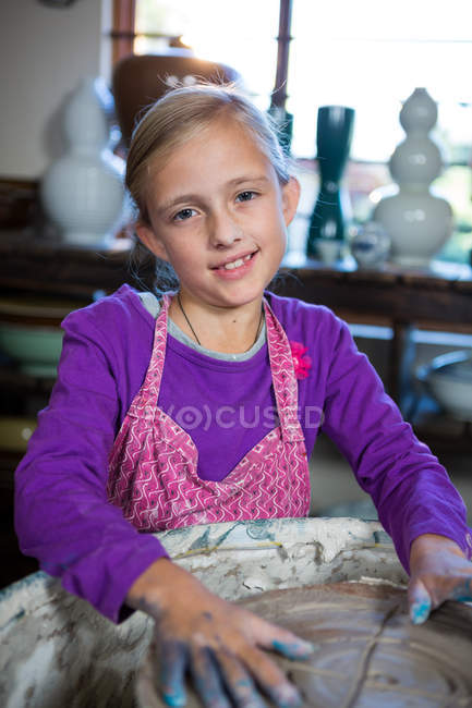 Portrait of girl making pot in pottery workshop — Stock Photo