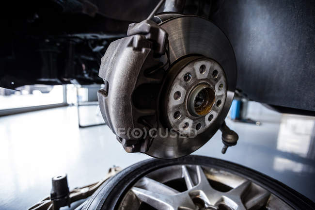 Close-up of break wheel and spare parts at repair garage — Stock Photo