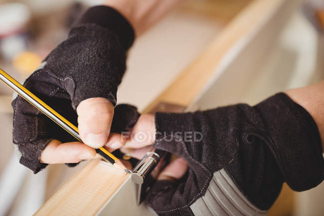 Image recadrée de charpentier marquant sur la porte avec crayon — Photo de stock