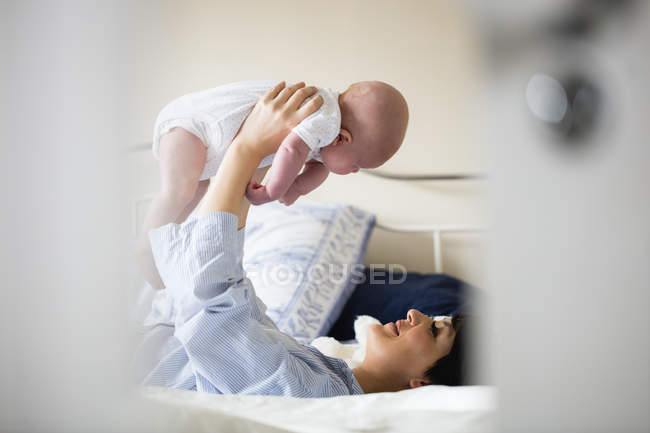 Mutter spielt zu Hause mit ihrem Baby im Schlafzimmer — Stockfoto