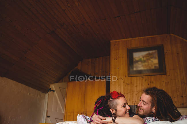 Sorridente giovane coppia hipster rilassante sul letto a casa — Foto stock