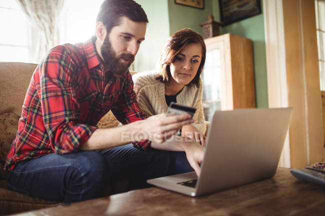 Casal de compras on-line no laptop na sala de estar em casa — Fotografia de Stock
