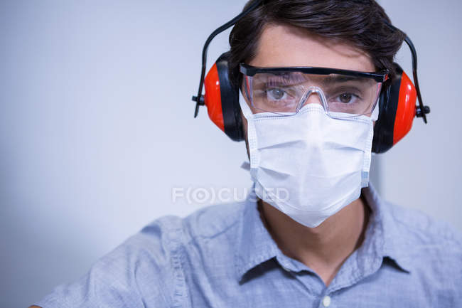 Portrait de dentiste en lunettes de protection et écouteurs — Photo de stock