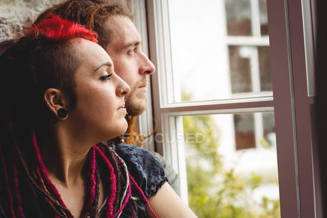 Young hipster couple by window at home — Stock Photo