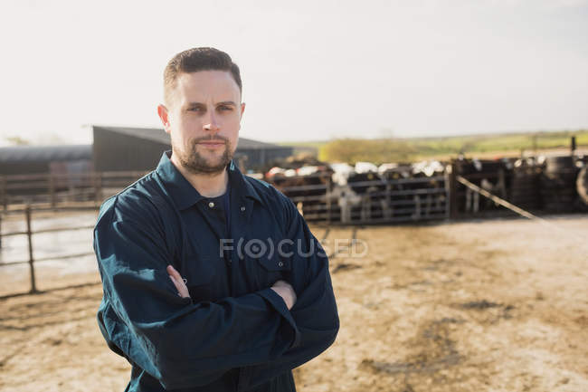 Портрет уверенного фермера, стоящего с оружием, скрещенным на поле боя — стоковое фото