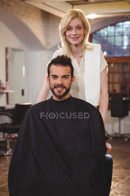 Портрет улыбающегося парикмахера и клиента в салоне — стоковое фото