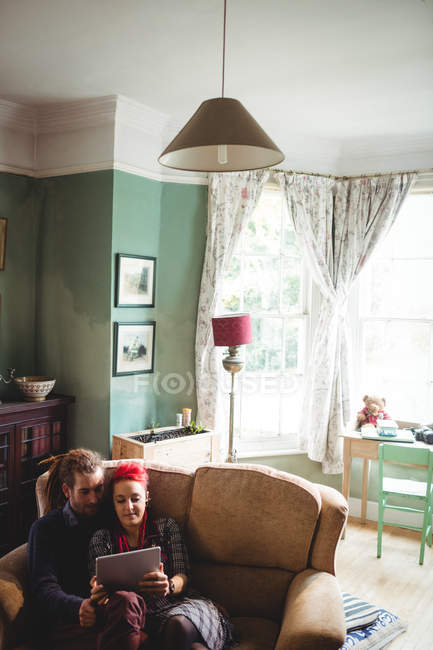 Хіпстерська пара використовує цифровий планшет на дивані вдома — стокове фото