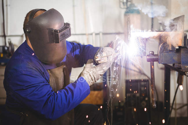 Welder welding metal in workshop — Stock Photo