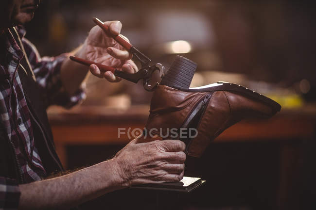 Mani di calzolaio riparare una scarpa in officina — Foto stock