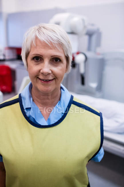 Retrato del médico sonriente de pie en la sala de rayos X del hospital - foto de stock