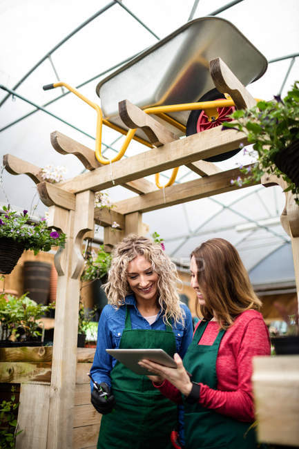 Two female florists using digital tablet at garden centre — Stock Photo