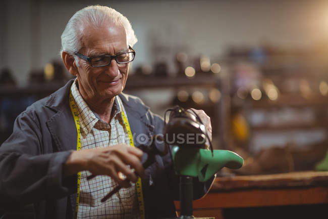 Shoemaker repairing a shoe in workshop — Stock Photo