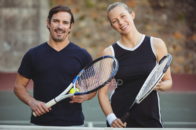 Two tennis players standing in sport court with rackets — Stock Photo