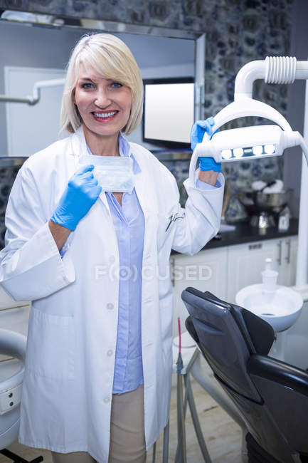 Retrato del dentista sonriente en la clínica dental - foto de stock
