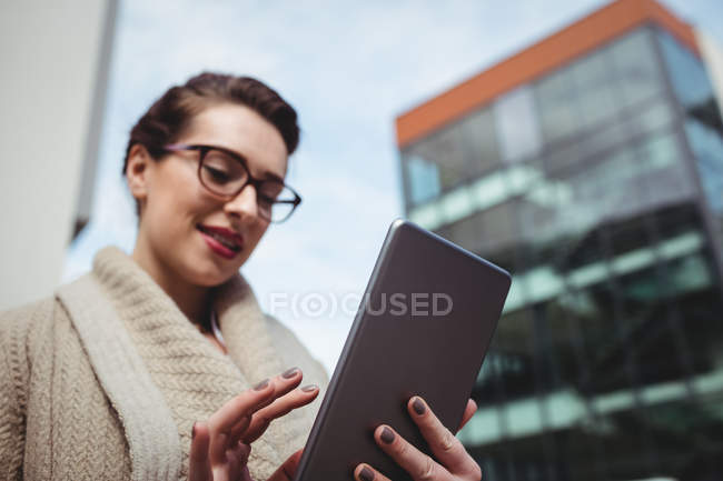 Young woman using digital tablet by building — Stock Photo