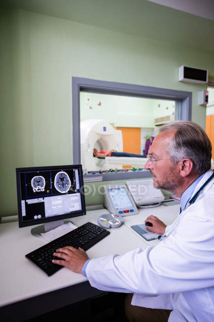 Medico che esamina la risonanza magnetica cerebrale sul computer in ospedale — Foto stock