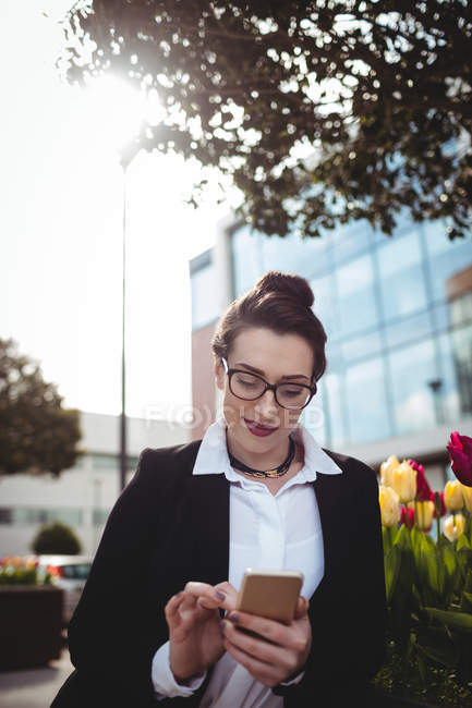 Beautiful young businesswoman using mobile phone — Stock Photo