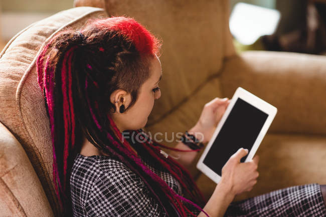 Hipster mulher usando tablet digital no sofá em casa — Fotografia de Stock