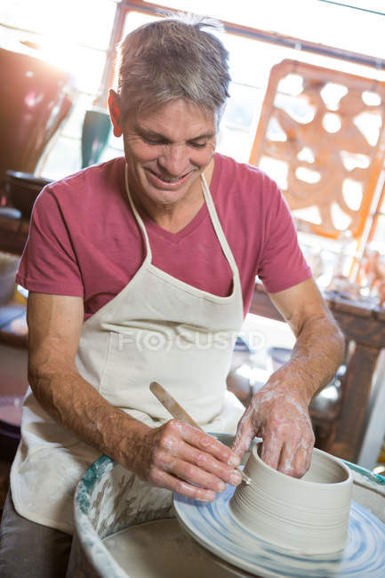 Oleiro macho feliz fazendo pote na oficina de cerâmica — Fotografia de Stock