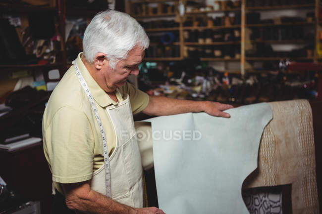 Chaussure examinant un morceau de cuir en atelier — Photo de stock