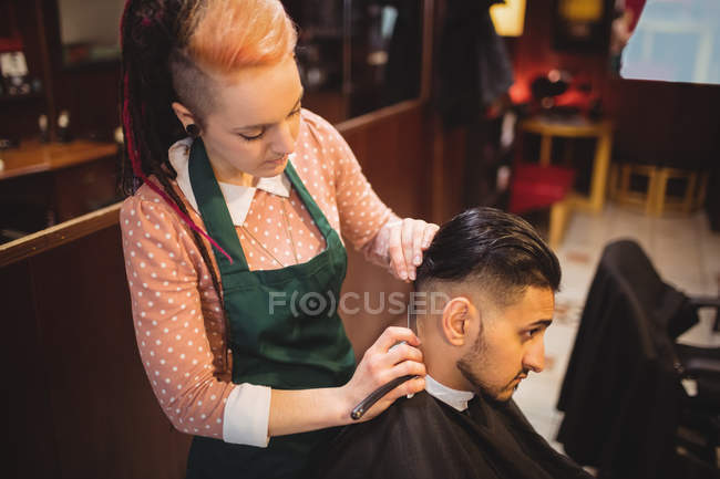 Hombre conseguir su pelo recortado con navaja de afeitar en la peluquería - foto de stock