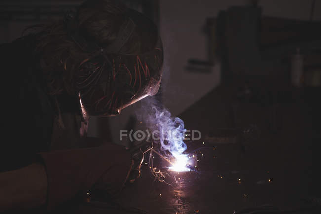Fabbro saldatura di un metallo in officina — Foto stock