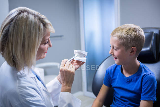 Dentiste montrant le modèle de bouche au patient à la clinique dentaire — Photo de stock