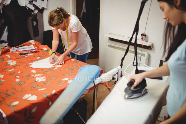 Modedesignerinnen arbeiten im Studio am Laptop — Stockfoto