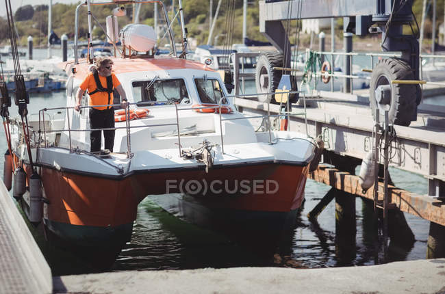 Человек, стоящий на лодке в море — стоковое фото