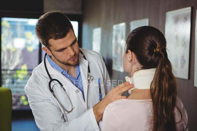 Fisioterapeuta examinando pescoço de paciente feminino na clínica — Fotografia de Stock