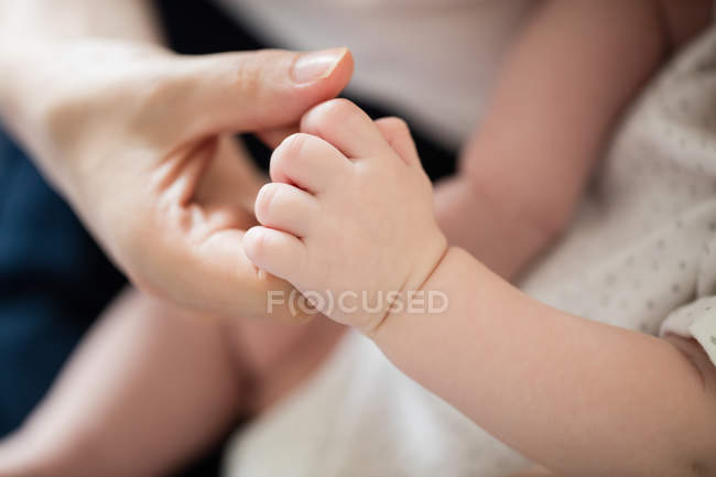 Обрізане зображення матері, яка торкається дитини — стокове фото