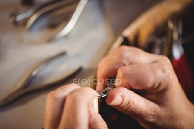 Zugeschnittenes Bild von Goldschmied, der Kette in Werkstatt vorbereitet — Stockfoto