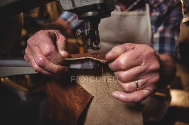 Mid section of shoemaker using sewing machine in workshop — Stock Photo