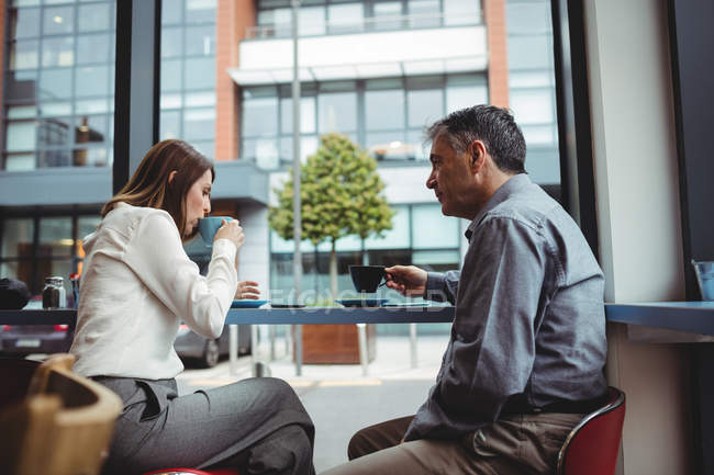 Man and woman having coffee in cafeteria — Stock Photo
