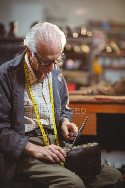 Calzolaio martellare su una scarpa in officina — Foto stock