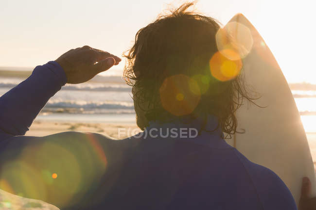 Surfer mit Blick aufs Meer am Strand — Stockfoto