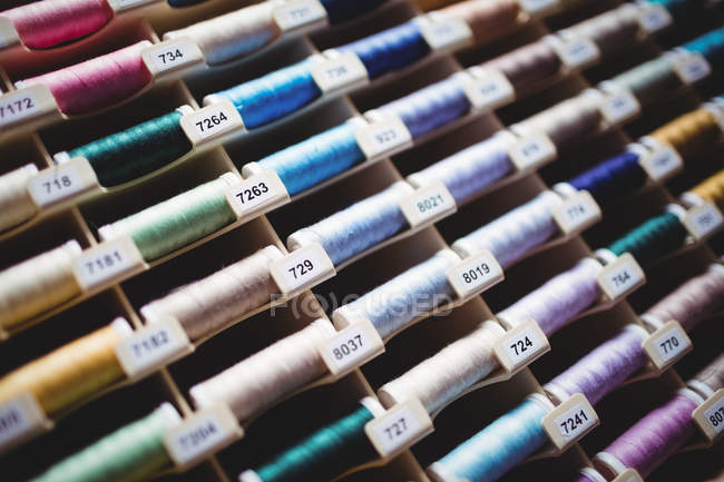 Bobines colorées de fils en boîte en studio de couture — Photo de stock