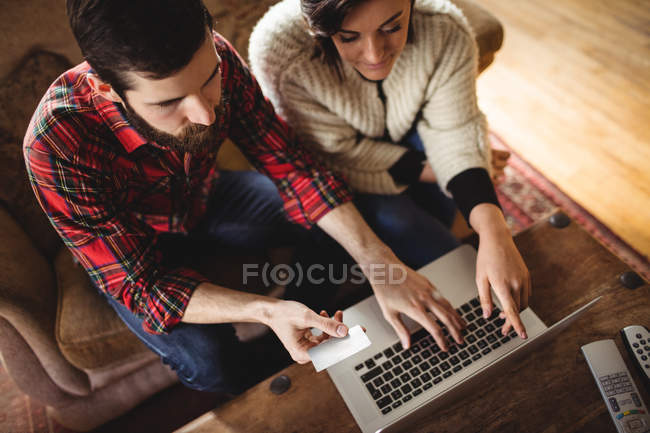 Couple shopping online on laptop in living room at home — Stock Photo