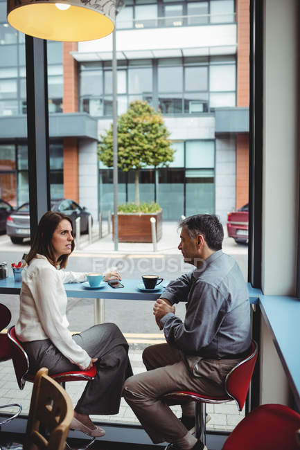Homme et femme en conversation à la cafétéria — Photo de stock
