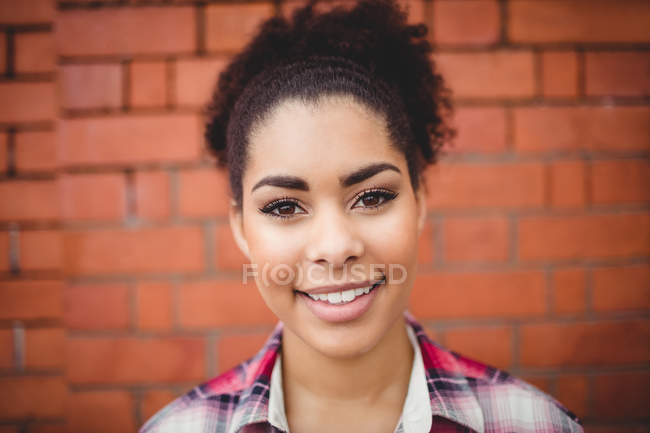 Nahaufnahme Porträt einer fröhlichen Frau gegen Ziegelmauer — Stockfoto