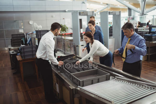Commuters collecting their bags from the security counter at airport — Stock Photo
