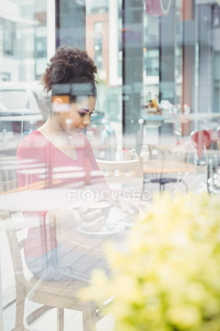 Compuesto digital de mujer joven usando el ordenador portátil en la ciudad - foto de stock
