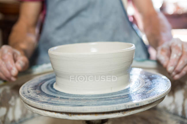 Mid section of potter making pot in pottery shop — Stock Photo