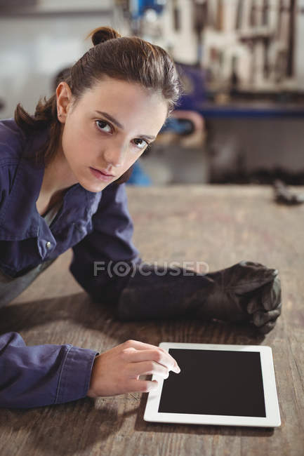 Retrato de soldador feminino usando tablet digital em oficina — Fotografia de Stock