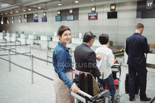 Passagers en attente à un comptoir d'enregistrement avec bagages à l'intérieur du terminal de l'aéroport — Photo de stock